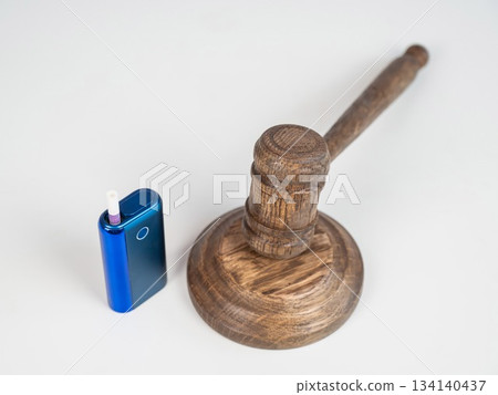 Judge's gavel and electronic cigarette. Smoking ban. Tobacco heating systems. Judge's gavel and electronic cigarette. Smoking ban. Tobacco heating systems. 134140437