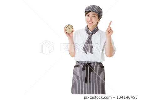 一位身穿廚師服的女子拿著一個鐘錶 一位身穿廚師服的女子拿著一個鐘錶 134140453