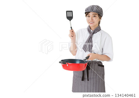 身穿廚師服的女子手持煎鍋 身穿廚師服的女子手持煎鍋 134140461