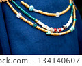 Beads in the old style against the background of blue linen fabric. Vikings, Slavs. Pastiche. 134140607