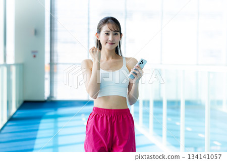 Woman with smartphone at the gym 134141057