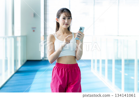 在健身房用智慧型手機的女人 134141061