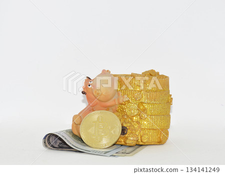 A gold Bitcoin coin and a coin box made from folded dollar bills. A gold Bitcoin coin and a coin box made from folded dollar bills. 134141249