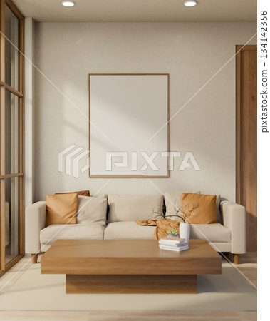 White frame on wall over sofa and wooden table with books and flower vase in a sun lit living room. 134142356