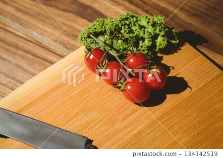 Tomatoes and parsley on chopping board 134142519