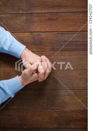 Man praying on wooden table Man praying on wooden table 134142707