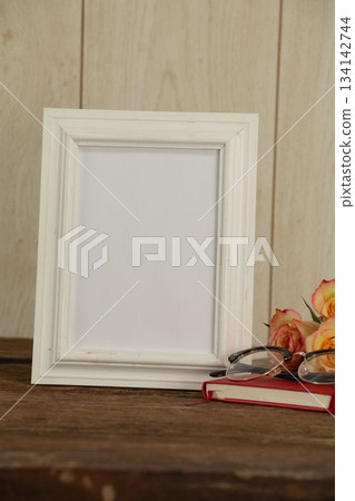 Photo frame, flowers and book on table Photo frame, flowers and book on table 134142744