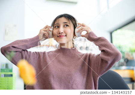 Asian businesswoman office worker holding a pen under chain looking at laptop on table in white room Asian businesswoman office worker holding a pen under chain looking at laptop on table in white room 134143157