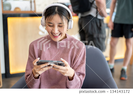 Asian businesswoman office worker holding a pen under chain looking at laptop on table in white room Asian businesswoman office worker holding a pen under chain looking at laptop on table in white room 134143172