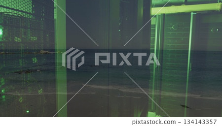 Green-tinted industrial frame rising on sandy shoreline amid mesh panels, beams, pipes, copy space 134143357