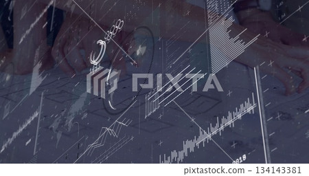 Designer hands overlaying charts on wireframe sketches at work desk, with smartwatch ring 134143381