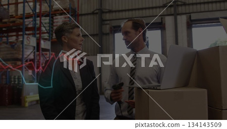 Warehouse staff in business attire scanning stock boxes using scanner and laptop at warehouse 134143509