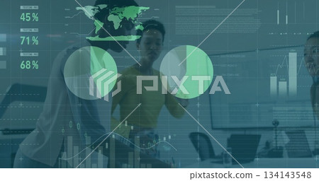 Presenting woman in yellow blouse pointing at global data overlay in conference room, with laptops 134143548