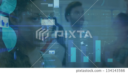 Gazing woman in blazer with headset viewing floating charts via glass panel in office, copy space 134143566