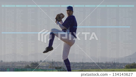 Pitching pitcher wearing jersey holding glove and ball on pitchers mound, with fence and bleachers 134143627