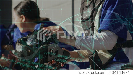 Handling VR headset woman wearing vest examining straps in lab, with DNA helix graphics, copy space Handling VR headset woman wearing vest examining straps in lab, with DNA helix graphics, copy space 134143685