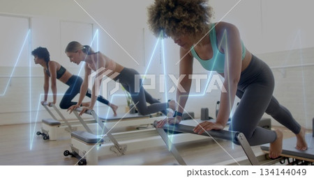 Holding plank sportswear-clad woman on reformer at Pilates studio, fitness tracker, copy space 134144049