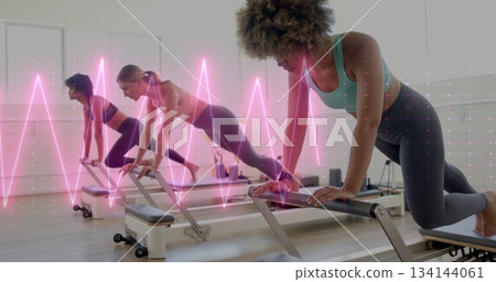 Woman in sportswear performing exercise on reformer in pilates studio, neon waveform, copy space 134144061