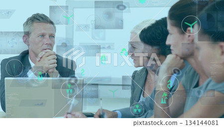 Thinking man in suit contemplating financial data around meeting table, with holograms, copy space 134144081