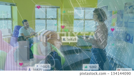 Presenting woman holding tablet showing metrics in office lounge with beanbags, charts, copy space 134144090