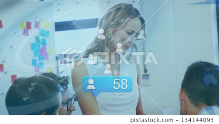 Presenting woman in white blouse leading team at computer in office, sticky notes, alert showing 58 Presenting woman in white blouse leading team at computer in office, sticky notes, alert showing 58 134144093