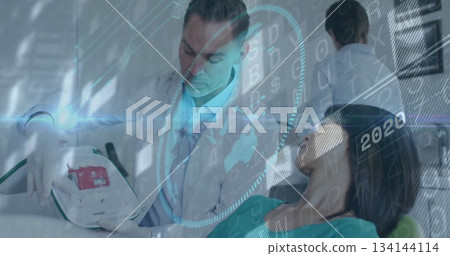 Middle-aged doctor holding portable device and examining patient on exam chair, with data overlays Middle-aged doctor holding portable device and examining patient on exam chair, with data overlays 134144114