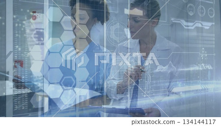 Doctor and nurse in medical attire reviewing records in clinic, with clipboard, holographic overlay 134144117