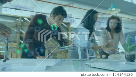 Discussing three professionals in business attire analyzing blueprint and digital overlay in office 134144126