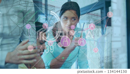 Manipulating analyst in turquoise top using stylus on display in office room with map grid overlay Manipulating analyst in turquoise top using stylus on display in office room with map grid overlay 134144130