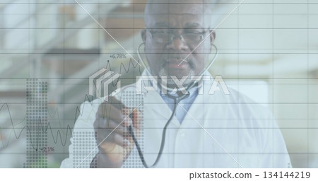 Senior doctor analyzing data on glass panel with overlay in lab, wearing lab coat and stethoscope 134144219