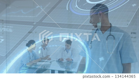 Standing doctor in scrubs watching team reviewing clipboards with holograms in hospital, copy space 134144365