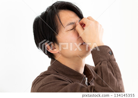 一位中年男子痛苦地摀著眼角。 134145355