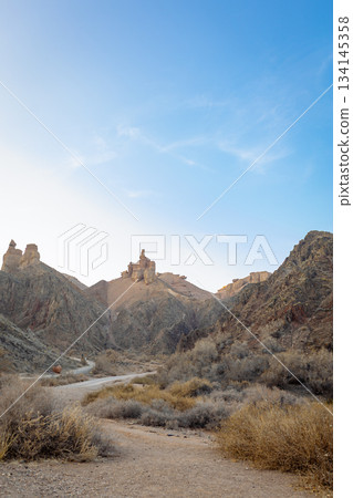 Wide shot of canyon with dusty road and rock castles - wild nature of Kazakhstan 134145358