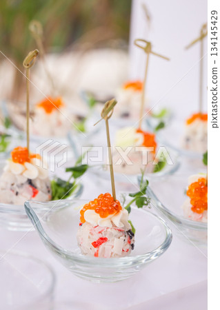 Close-up of canape with red caviar in glass dish on white background - luxurious appetizer Close-up of canape with red caviar in glass dish on white background - luxurious appetizer 134145429