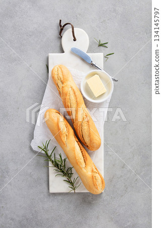 Fresh Baguettes on Marble Cutting Board with Parchment Paper 134145797