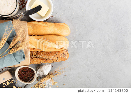 Assorted Baguettes with Butter, Flour, and Seeds on Table Assorted Baguettes with Butter, Flour, and Seeds on Table 134145800