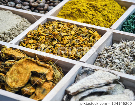 Variety of spices and herbs displayed in wooden boxes at a market in the evening 134146260