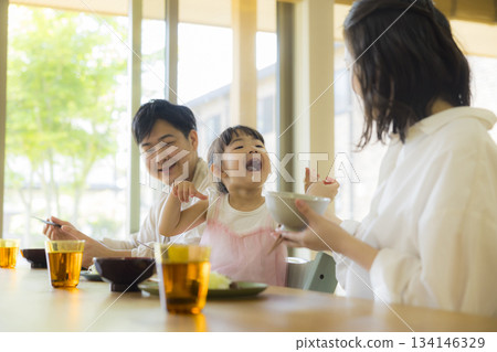 一家人其樂融融地圍坐在餐桌旁 134146329