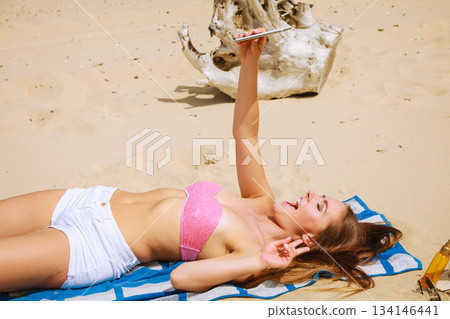 Happy girl taking selfie photo on beach. Happy girl taking selfie photo on beach. 134146441