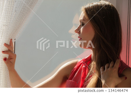 Woman looking through window, relaxing Woman looking through window, relaxing 134146474