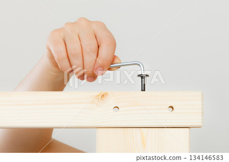 Assembling wooden furniture using scredriver. DIY. 134146583