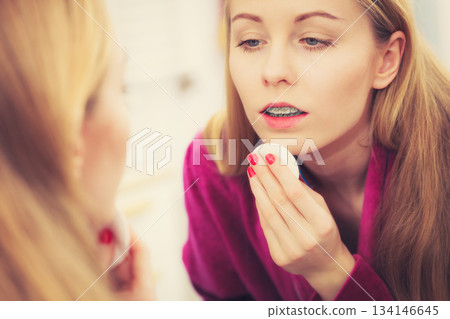 Woman using cotton pad to remove make up 134146645