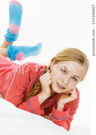 Smiling woman lying in bed 134146667