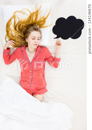Young woman lying on bed wearing pajamas 134146670