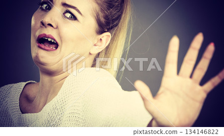 Scared woman gesturing stop gesture with hands 134146822