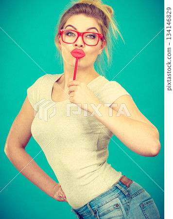 Happy woman holding fake lips on stick Happy woman holding fake lips on stick 134146829