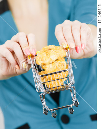 Woman hand holding shopping cart with sweet bun 134146843