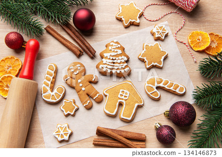 Homemade gingerbread cookies on baking paper for christmas Homemade gingerbread cookies on baking paper for christmas 134146873