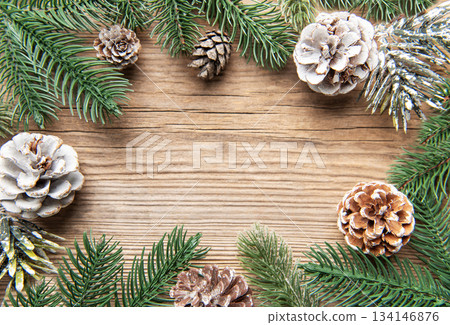 Christmas pine cones and fir branches on wooden background Christmas pine cones and fir branches on wooden background 134146876