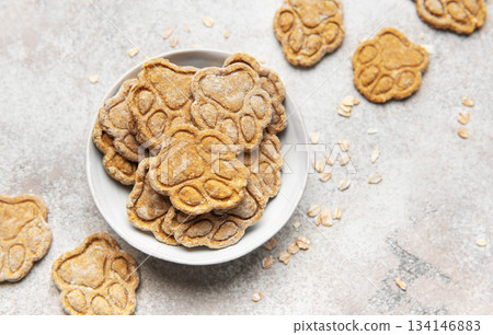 Paw print dog treats in bowl with oats 134146883
